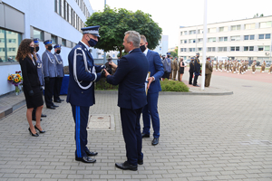 Komendant policji odbiera upominek od Wojewody.