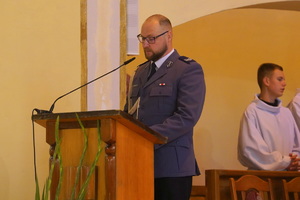 policjant przemawia w kościele do zebranych