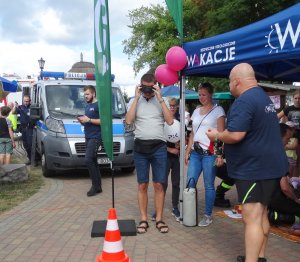 Pokaz sprzętu radiowozu, sprzętu policyjnego i akcesoriów podczas festynu pn. &quot;Bezpieczny Wypoczynek nad Jeziorem Wielkim Cekcyńskim&quot;.