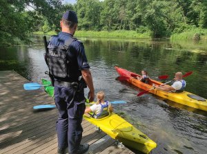 policjant obserwuje płynących kajakarzy