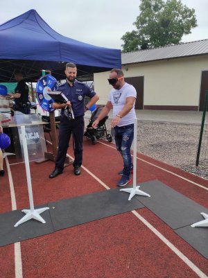 policjant obserwuje mężczyznę poruszającego się po torze przeszkód