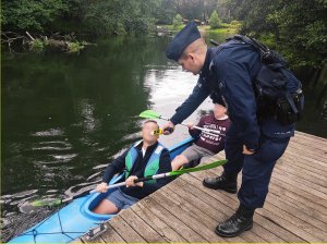 Policjant kontroluje trzeźwość kajakarzy.