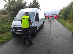 policjant podczas oględzin rozbitego pojazdu