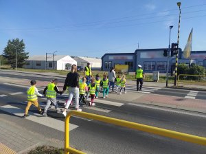 policjant przeprowadza dzieci przez przejście dla pieszych