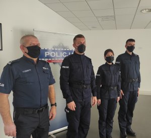 policjanci po odebraniu gratulacji od komendanta pozują do zdjęcia