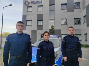 policjanci stoją przed radiowozem