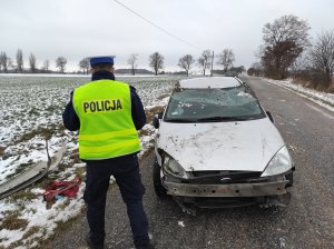 policjant wykonuje oględziny rozbitego auta