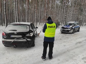 policjant podczas oględzin uszkodzonego auta