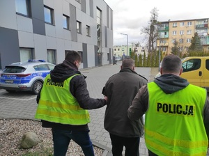 policjanci prowadzą zatrzymanego mężczyznę