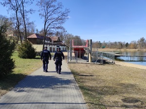 policyjny patrol pieszy patroluje deptak nad jeziorem