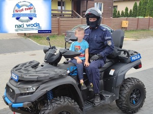 dziecko z policjantem siedzi na policyjnym quadzie
