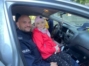 policjant pozuje do zdjęcia z dzieckiem