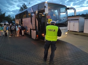 policjant sprawdza stan techniczny autokaru