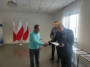 pracownik cywilny otrzymuje gratulacje od Komendanta