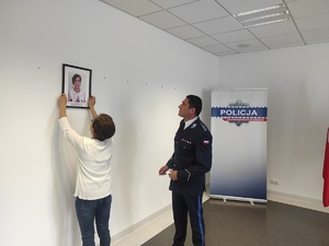 pracownik cywilny zawiesza zdjęcie pamiątkowe