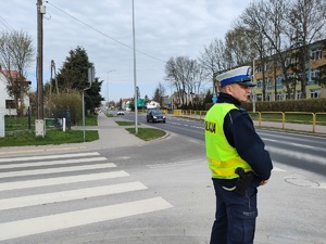 policjant pilnuje bezpieczeństwa w rejonie przejścia dla pieszych