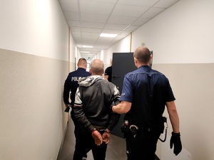 policjanci prowadzą sprawcę włamania