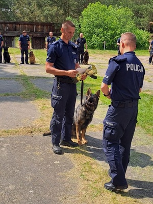 policjant odbiera puchar i gratulacje od Komendanta