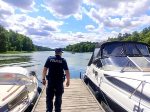 policjant czuwa nad bezpieczeństwem osób wypoczywających nad wodą