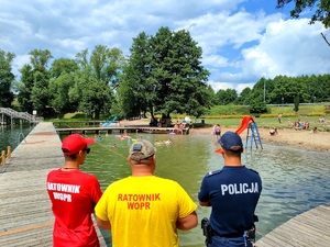 policjant i ratownicy wodni czuwają nad bezpieczeństwem osób wypoczywających nad wodą