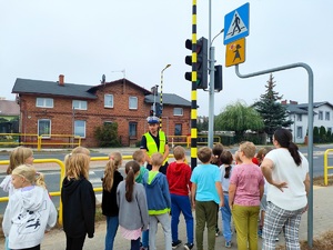 policjant omawia zasady bezpieczeństwa podczas przechodzenia przez jezdnię