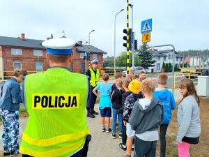 policjant omawia zasady bezpieczeństwa podczas przechodzenia przez jezdnię