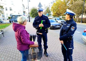 policjanci wręczają pieszej odblask