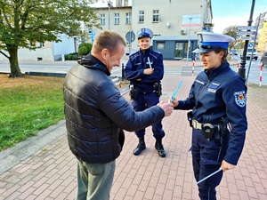 policjanci wręczają pieszemu odblask