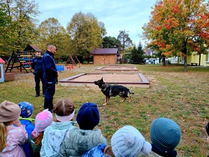 policjant prezentuje dzieciom policyjnego psa