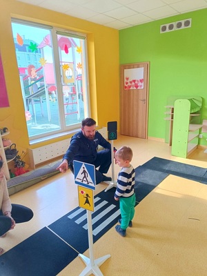 policjant uczy dzieci zasad poruszania się po drogach