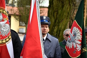 policjant stoi przy sztandarze