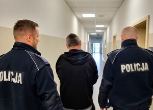 policjanci prowadzą zatrzymanego
