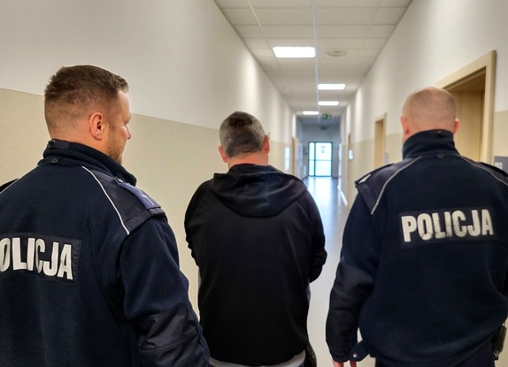 policjanci prowadzą zatrzymanego