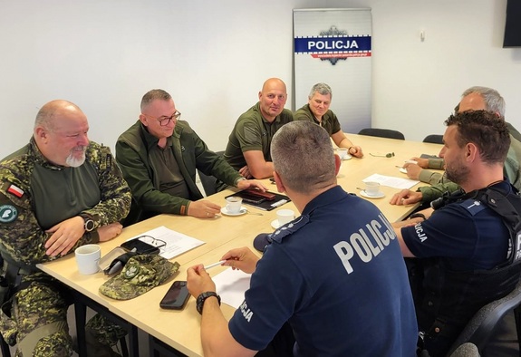 policjanci rozmawiają z leśnikami