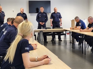 policjanci siedzą i słuchają przemówienia