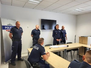 policjanci siedzą i słuchają przemówienia