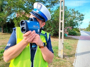 policjant weryfikuje prędkość pojazdów
