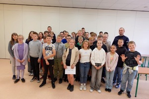 policjanci pozują z uczniami do pamiątkowego zdjęcia