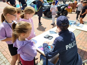 policjantka pokazuje dzieciom zabezpieczone ślady