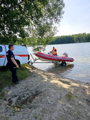 policjant i strażak wodują łódź