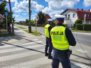 Policjanci stoją i obserwują ruch na trasie