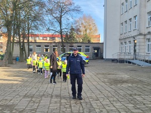 policjant prowadzi dzieci