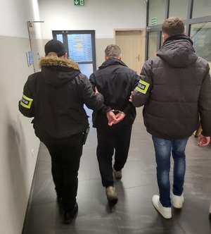 policjanci prowadzą mężczyznę