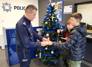 dzieci przekazują świecę policjantowi