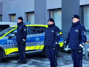 policjanci stoją przy radiowozie