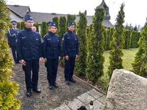 policjant i uczniowie oddają hołd poległym