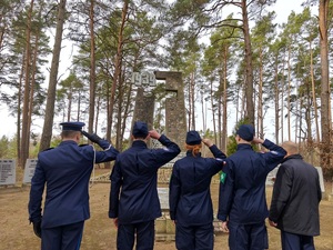 policjant i uczniowie oddają hołd poległym