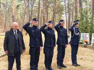 policjant i uczniowie oddają hołd poległym
