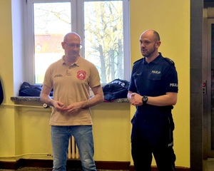 Policjant i strażak prowadzą zajęcia z pierwszej pomocy.