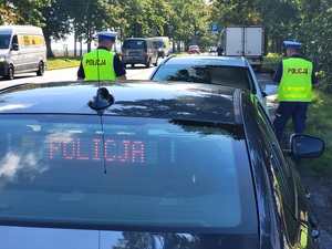 policjant przeprowadza kontrolę drogową
